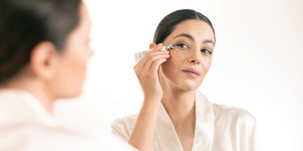 Woman applying a Reine Blanche product under her eye
