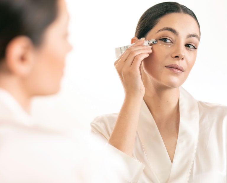 Woman applying a Reine Blanche product under her eye